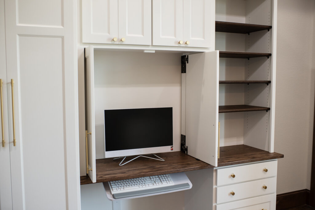 showing the computer hidden behind pocket doors in a built-in desk